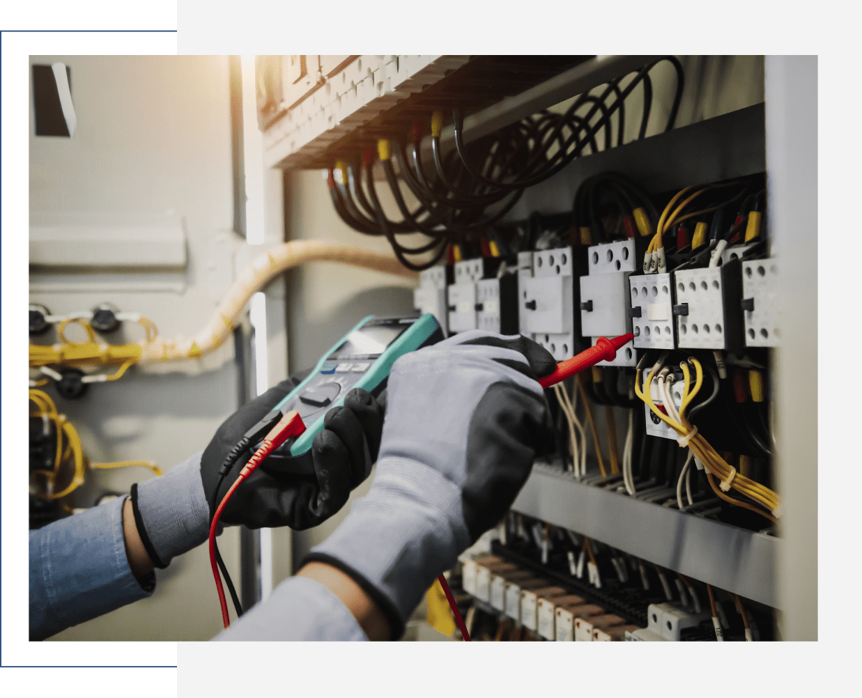 Electrician testing electrical panel with multimeter.