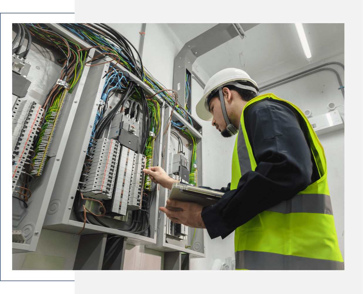 Electrician inspecting electrical panel with clipboard.